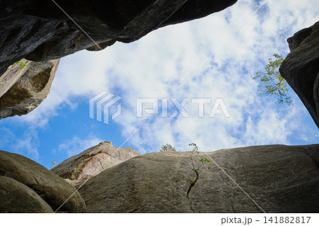 massive rock walls under a bright blue sky with fluffy white clouds massive rock walls under a bright blue sky with fluffy white clouds 141882817