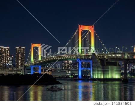 虹色に特別ライトアップされたレインボーブリッジと東京湾の水面に映る夜景 141884602