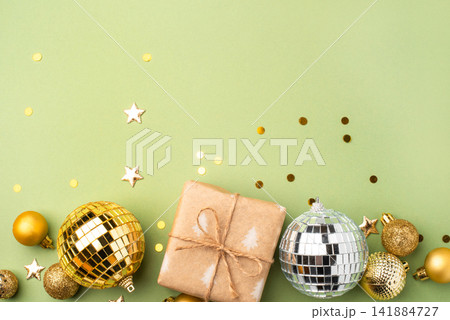 Christmas gift with ornaments on a green background Christmas gift with ornaments on a green background 141884727