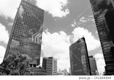 大都市の鼓動・名古屋駅前の超高層ビル群とドラマチックな夏空の見上げスナップ 141884894