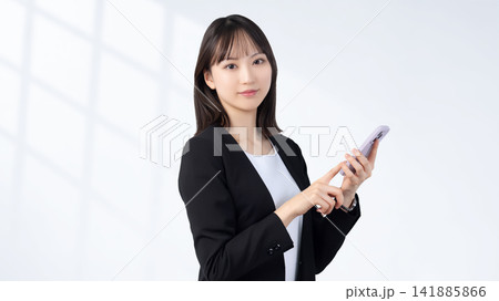 スマートフォンを持つ女性・ビジネスウーマン スマートフォンを持つ女性・ビジネスウーマン 141885866