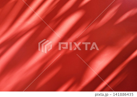 Vibrant red surface with natural shadow and light overlay texture for professional abstract design background. 141886435
