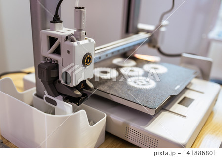 Close up of a 3d printer creating small gear parts on the build plate in a workshop, modern manufacturing and prototyping Close up of a 3d printer creating small gear parts on the build plate in a workshop, modern manufacturing and prototyping 141886801