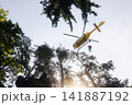 Rescuer on rope under a flying helicopter of emergency medical service 141887192