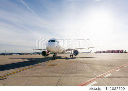 Front view of airplane taxiing to runway on sunny airport day Front view of airplane taxiing to runway on sunny airport day 141887200