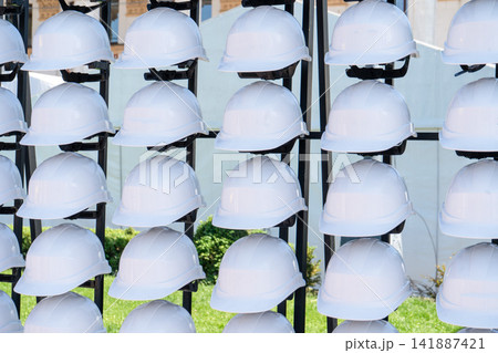 White Construction Hard Hats helmet on a Storage Rack for Safety and Protection at Industrial Work White Construction Hard Hats helmet on a Storage Rack for Safety and Protection at Industrial Work 141887421
