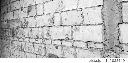 Monochrome concrete block wall with handprints 141888349