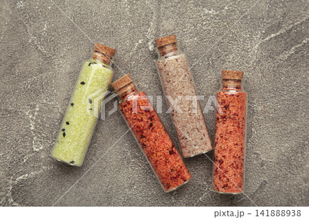 Set of different Himalayan salt in glass bottle with wooden cap on grey concrete background Set of different Himalayan salt in glass bottle with wooden cap on grey concrete background 141888938