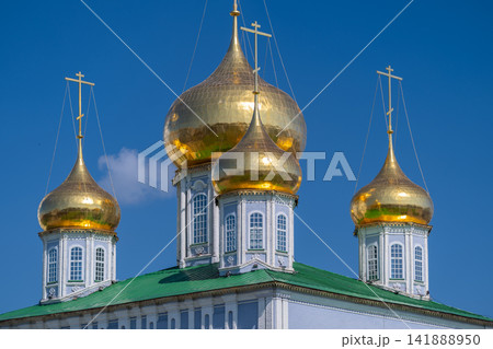 Golden domes shine brightly above the Cathedral of the Assumption in Tula on a clear day showcasing architectural beauty against the blue sky Golden domes shine brightly above the Cathedral of the Assumption in Tula on a clear day showcasing architectural beauty against the blue sky 141888950