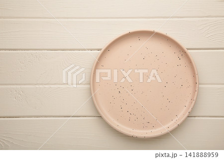 Empty ceramic plate, beige round tray plate on white wooden background. 141888959