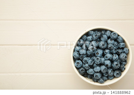 Blueberry in bowl on light wooden background. Space for text 141888962