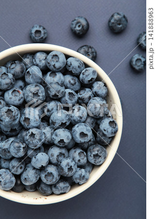 Blueberry in bowl on dark blue background. Vertical photo 141888963
