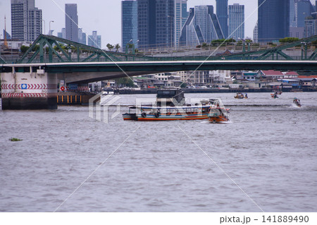 View of motorboats and passenger boats navigating the Chao Phraya River near Memorial Bridge 141889490