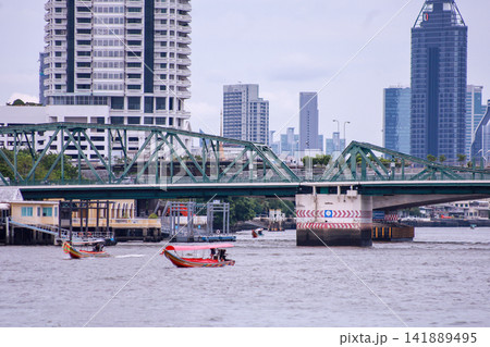 View of motorboats and passenger boats navigating the Chao Phraya River near Memorial Bridge 141889495
