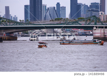 View of motorboats and passenger boats navigating the Chao Phraya River near Memorial Bridge 141889498