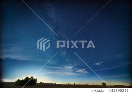 Vast expanse of the Milky Way Galaxy illuminating the night sky over a tranquil landscape Vast expanse of the Milky Way Galaxy illuminating the night sky over a tranquil landscape 141890251