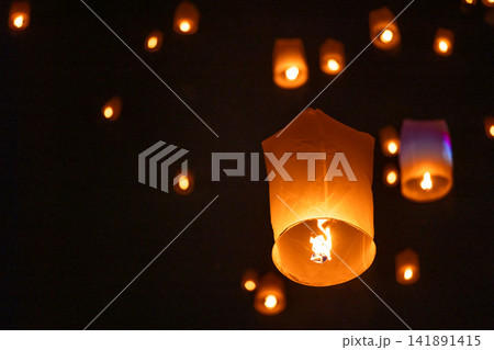 Sky lantern floating in the dark night sky, Tourist floating sky lanterns, Sky lanterns floating on night of Yi Peng, Loy Krathong Festival or Yi Peng Festival in Chiang Mai Thailand. Sky lantern floating in the dark night sky, Tourist floating sky lanterns, Sky lanterns floating on night of Yi Peng, Loy Krathong Festival or Yi Peng Festival in Chiang Mai Thailand. 141891415