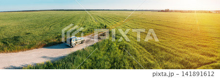 Aerial view of Renault Duster car SUV parked near countryside road in field rural landscape. Aerial view of car SUV parked near countryside road on a sunny summer evening. Panorama, panoramic view Aerial view of Renault Duster car SUV parked near countryside road in field rural landscape. Aerial view of car SUV parked near countryside road on a sunny summer evening. Panorama, panoramic view 141891612