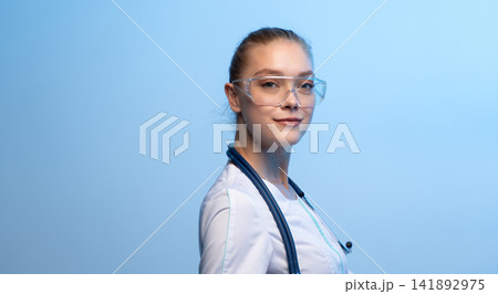 Young female doctor wearing safety glasses and stethoscope Young female doctor wearing safety glasses and stethoscope 141892975