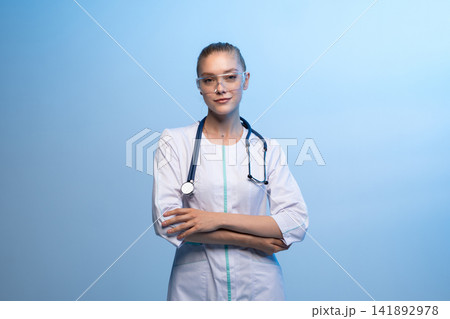 Female doctor wearing safety goggles and stethoscope Female doctor wearing safety goggles and stethoscope 141892978