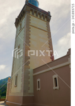 Lighthouse tower on a sunny day in Tangier, Morocco overlooking coastal landscape Lighthouse tower on a sunny day in Tangier, Morocco overlooking coastal landscape 141893715