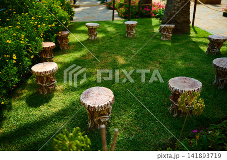 Circular wooden garden stools arranged on a green lawn for outdoor seating in Tangier 141893719