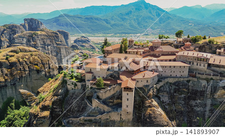 Aerial view of Holy Monastery of Saint Stephen built on high rock cliff in Meteora complex with mountain valley background near Kalabaka Thessaly region Greece 141893907