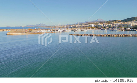 Panoramic aerial view of Rethymno port harbor and stone breakwater with Crete mountain range under clear blue sky on sunny day in Greece island 141893919