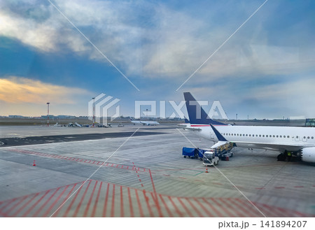 Airplane Wing and Engine on Airport Runway at Sunset View Airplane Wing and Engine on Airport Runway at Sunset View 141894207