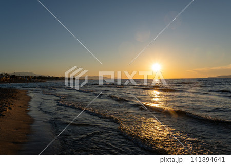 Bright golden sunset over ocean waves with sun reflection on sea surface 141894641