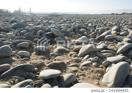 Rocky Riverbed Landscape with Smooth Pebbles and Dry Terrain Rocky Riverbed Landscape with Smooth Pebbles and Dry Terrain 141894685