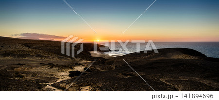 Sunset Coastline Over Volcanic Cliffs and Calm Ocean Sunset Coastline Over Volcanic Cliffs and Calm Ocean 141894696
