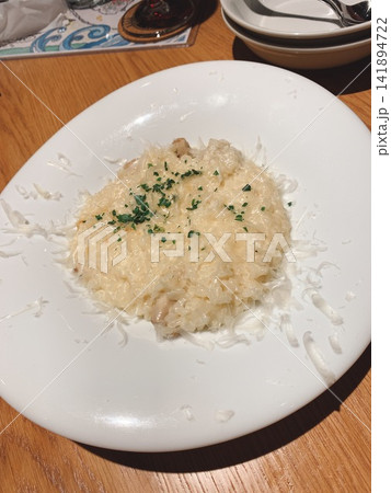 削りチーズとパセリが散らされた濃厚でクリーミーなリゾット 削りチーズとパセリが散らされた濃厚でクリーミーなリゾット 141894722