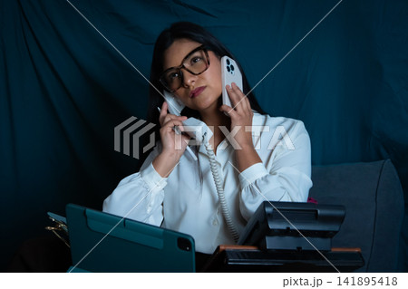 Woman juggling multiple calls managing overwhelming office communication Woman juggling multiple calls managing overwhelming office communication 141895418