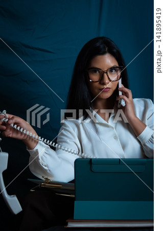 Businesswoman multitasking with phone calls and technology Businesswoman multitasking with phone calls and technology 141895419