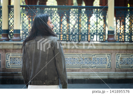 Man with long hair looking at moorish kiosk Man with long hair looking at moorish kiosk 141895576