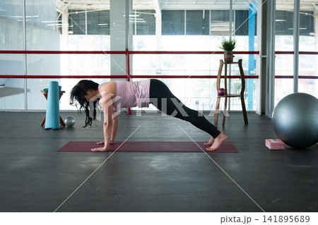 Woman exercising plank pose on yoga mat indoors Woman exercising plank pose on yoga mat indoors 141895689