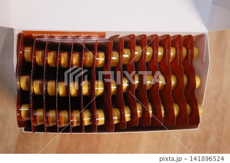Box of Yellow Capsules in Brown Blister Packs 141896524