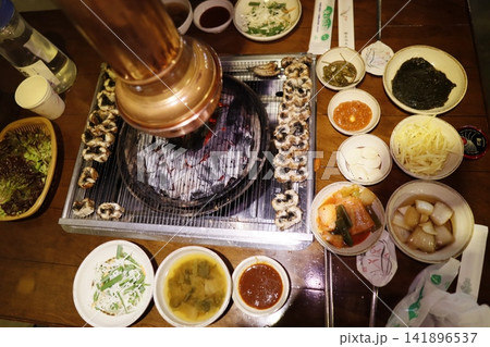 Korean BBQ Feast with Side Dishes and Grill 141896537