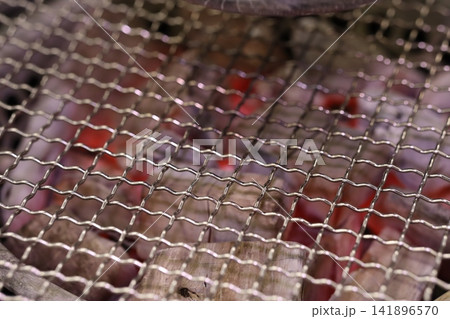 Close-up of Metal Grill Mesh Over Glowing Coals Close-up of Metal Grill Mesh Over Glowing Coals 141896570