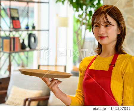 トレイを持つカフェ店員 141897033