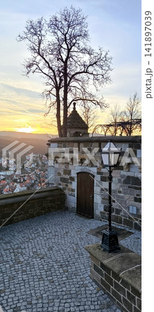 Castle observation deck with a lantern against the backdrop of a sunset over the city. Wernigerode, Germany 141897039