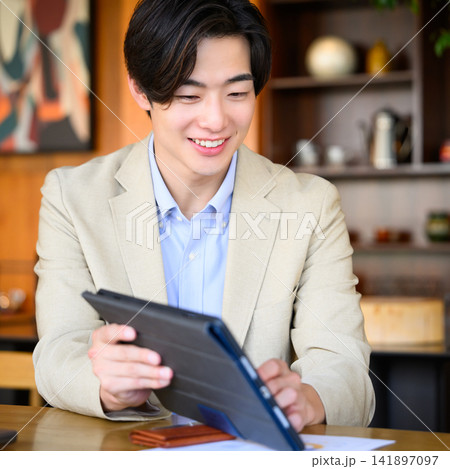 タブレットを見る笑顔の男性 141897097