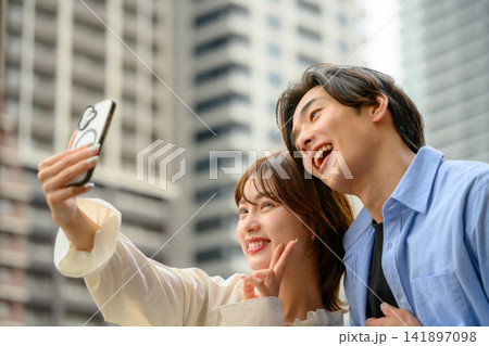 カップルがスマホで自撮りを楽しむ 141897098