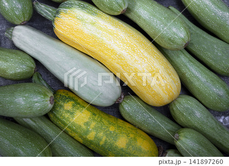 Colorful zucchini arranged on wood with a farm background, showing fresh organic produce for food, farming, and retail. Colorful zucchini arranged on wood with a farm background, showing fresh organic produce for food, farming, and retail. 141897260