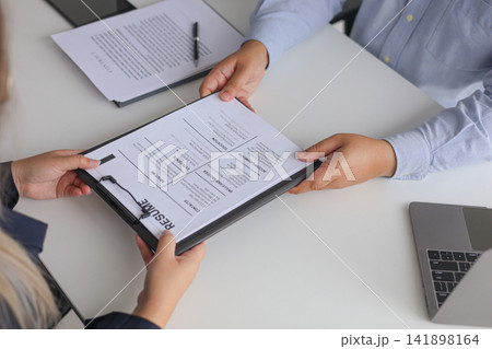 Close-up Job Interview, Female Candidate Handing Resume to Hiring Manager. 141898164