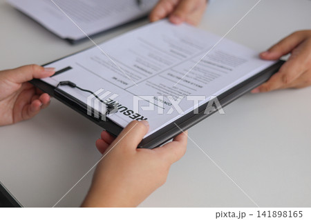 Close-up Job Interview, Female Candidate Handing Resume to Hiring Manager. 141898165