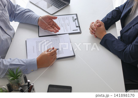 Human Resources Manager Discussing Contract and Legal Agreement for New Employee After Successful Job Interview. Human Resources Manager Discussing Contract and Legal Agreement for New Employee After Successful Job Interview. 141898170