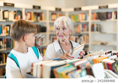 Grandmother and grandson choosing books in bookstore Grandmother and grandson choosing books in bookstore 141898466