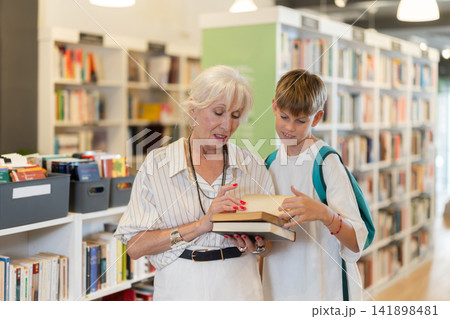 In bookstore grandson with grandmother choose book 141898481